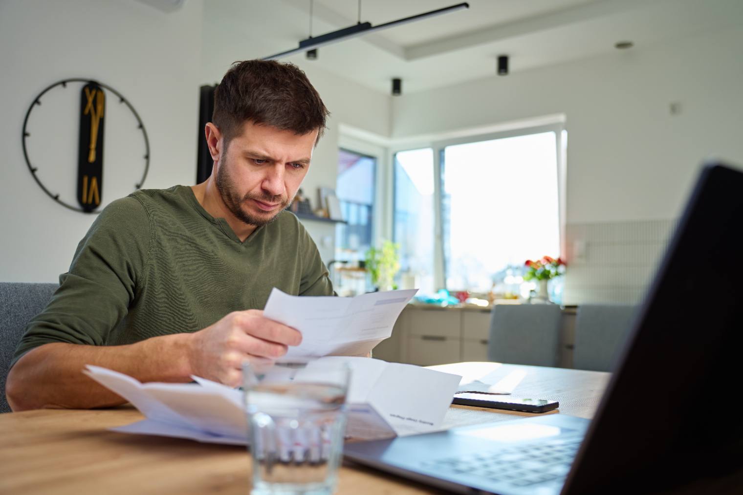 Landlord reviewing tenancy paperwork at a kitchen table