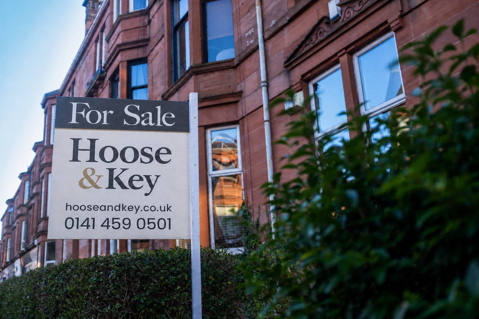 Hoose & Key For Sale board outside a red sandstone tenement in Glasgow